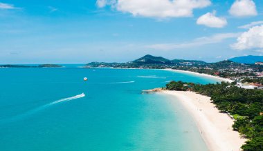 Turkuaz berrak deniz suyuyla beyaz kumsal manzarası. Kumsalda otelleri olan resimli gölün kuş bakışı panoramik manzarası. Tayland 'da nüfuslu bir ada. Su Sporu Etkinliği