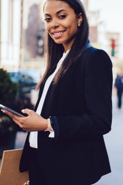 Neşeli Afro-Amerikan ofis çalışanı portresi kamera kopyalama alanı alanı yakınındaki gülümseyen formal giyim giymiş. Avukat profil sayfası smartphone ayakta şehir merkezinde güncelleştirme başarılı koyu derili
