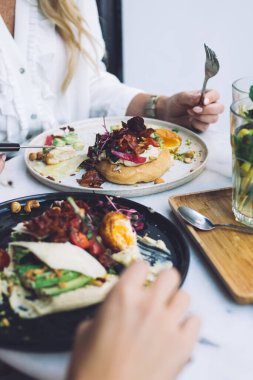 Bayan arkadaşların kafeteryada birlikte yemek yerken çekilmiş görüntüsü sağlıklı sebzelerin tadını çıkaran kadınlar, sağlıklı beslenme menüsü ve yaşam tarzı için modern mutfakların lezzetli yemeklerinden tatmin olan kadınlar.