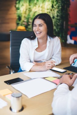 Mutlu erkek ve kadın çalışanlar dostane bir atmosferde iş birliği yapıyor şakalaşıyor, başarılı ve yetenekli tasarımcılardan oluşan bir ekip gülüyor proje için yaratıcı fikirleri paylaşıyorlar.