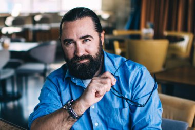 Kafkas kökenli, 40 'lı yaşlarda serbest çalışan, modern teknolojileri kullanarak Kafe' nin iç kısımlarında çalışıyor. Kameraya bakıyor, kendine güvenen, olgun bir adam. Akıllı telefon numarası tutuyor.