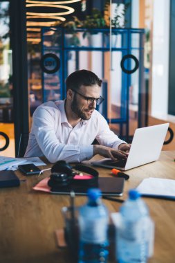 Kafkas erkek yazılım geliştirici dizüstü bilgisayarla birlikte çalışıyor ve yayın fikri yaratıyor, milenyum çalışanı serbest iş sırasında mesajlaşma ve ağ oluşturmak için ağ kitabı kullanıyor.