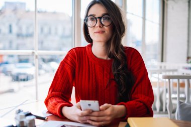 Kafkasyalı güzel bir kadın üniversitenin rahat kafeteryasında dinlenirken akıllı telefonu elinde tutuyor, gözlüklü çekici hippi kız gözlerini kaçırıyor ve kapalı cep telefonuyla 4G 'ye bağlanıyor.