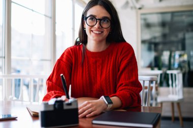 Neşeli başarılı bayan öğrenci, kafeteryada kafeterya hakkında düşünürken, yan tarafa bakıyor. Gözlüklü mutlu hippi kız, üniversite kütüphanesinde tatlı bir gülümsemeyle öğreniyor.