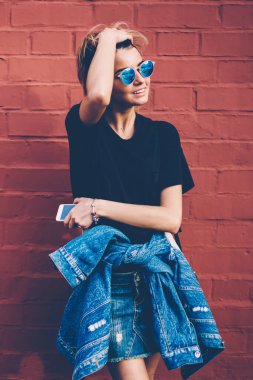 Başarılı bir bayan öğrenci, yüzünde olumlu bir gülümsemeyle, tanıtım geçmişinin yanında bekleyen bir arkadaş, neşeli hippi kız sokakta takılıyor, dışarıda boş zaman geçiriyor.