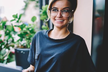 Neşeli gülümseyen yeniyetme kız 20 'li yaşlarda arkadaşlarıyla bilgisayar başında sohbet ediyor ve rahat kafeteryada boş zaman geçiriyor. Gelişmiş dizüstü bilgisayarla işten uzaklaşırken komik videolar çeken mutlu bir kadın.