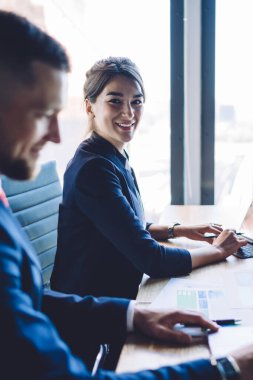 Başarılı erkek meslektaşı ile birlikte bankacılık alışverişini bilgi ve iş konseptiyle kontrol etmek için finansal web sitesinde çalışırken kameraya gülümseyen neşeli CEO portresi