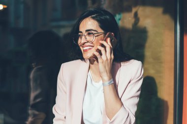 Göz düzeltmesi için optik gözlük takan neşeli kadın milenyumu. Kaldırım kafeteryasında planlama yaparken arkadaşınla uluslararası iletişimin keyfini çıkarıyor. Gezmek için gezen zengin kadın.