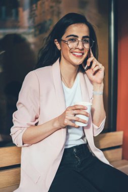 Klasik gözlüklü Gürcü kadın portresi kahve saatinde cep telefonu sohbetinden zevk alıyor, gözlüklü mutlu kadın boş zamanlarında akıllı telefon iletişimi yapmak için gezinen bağlantıyı kullanıyor.