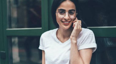 Şehir ortamında cep telefonu sohbetinden keyif alan başarılı kadın ressamın portresi dizüstü bilgisayarlı mutlu İspanyol kadın iletişim kurmak için uluslararası telefon görüşmesi yapıyor.