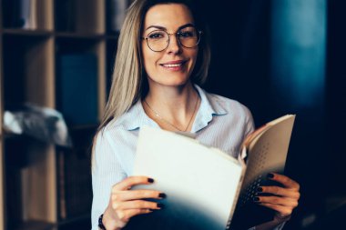 Yarım uzunluk portre çekici neşeli kadın Blogger gözlük gözleri koruma kapalı dinlenme zevk için. Kameraya Dergisi elele süre seyir muhteşem duygusal hippi kız