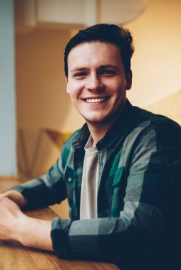 Kahve molası mutlu adam kamera cep telefonu ağ için iyi kablosuz bağlantı ile memnun gülümsüyor seyir telefon yoluyla sohbet keyfini rahat kıyafet neşeli hipster adam portresi