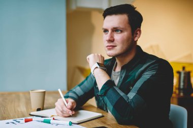 Not Defteri'nde, masaüstü Kırtasiye ve kağıtları ile oturma alanı coworking ödev proje yapıyor akıllı erkek öğrenci metin yazma makale oluşturma için fikir düşünüyorum yetenekli hipster adam