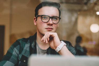 Ciddi erkek serbest meslek kafe iç, dizüstü bilgisayarda çalışma işlemi sırasında durulması gözlük netbook çevrimiçi eğitim yakın oturan çözümleri hakkında düşünme düşünce hipster adam