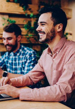 Kampüs arkadaşıyla, modern teknolojileri kullanarak Üretken işlemle memnun mutlu müreffeh serbest zaman harcama dizüstü bilgisayarda öğrenme komik şaka komik neşeli erkek öğrenci