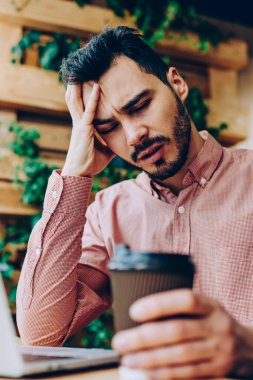 Kapalı gözlü, yorgun ve üzgün bir erkek öğrenci. Sınavlara hazırlanma sorunları yüzünden üzgün. Aşırı çalışan hippi çocuk çalışma alanında fazla çalışıyor.