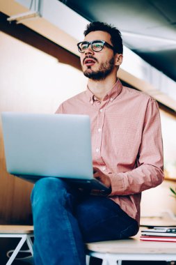 Birlikte oturma içinde yazıhane yaratıcı çözümler yapma projesi tamamlamak için yetenekli erkek programcılar bilgi analiz modern dizüstü bilgisayarlar çalışan genç erkekler ağlarda göz.