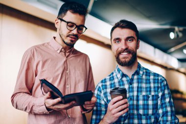 Erkek arkadaşınızın arkadaşıyla ile işbirliği zevk kamera bakarak gülen Defteri'nden, bilgi okuma meslektaşım ile kahve Kupası ayakta adamla neşeli sakallı hippi portresi