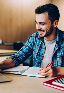 Neşeli genç erkek öğrenci eğitim webinar ders planı, mutlu yetenekli freelancer Gözat video içinde not etmek için kişisel blog makale oluşturma netbook üzerinde hazırlanması dizüstü bilgisayar üzerinde zevk