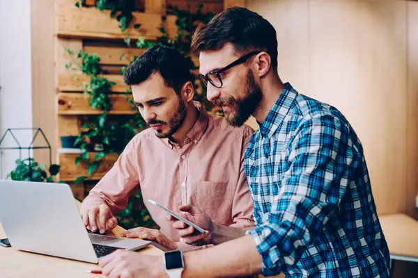 Profesyonel geliştiriciler dizüstü bilgisayarda güncelleme yazılımları birlikte çalışabilirliği kontrol ediyorlar, genç hipster gençler internet sayfasından bilgi okuyor ve internet üzerinden rezervasyon yapıyorlar.