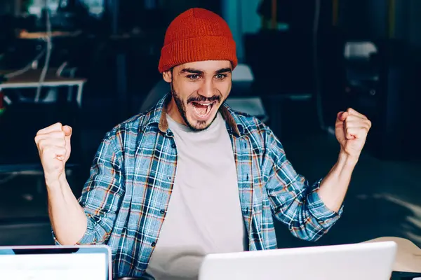 Dizüstü bilgisayarda çalışan erkek çalışanın arka planda ekranı taklit ederken, elleri havada olan duygusal meslektaşı zafer çığlıkları atıyordu. Hipster adam futbol maçı çevirisine hayran kalmıştı.