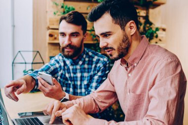 İki erkek meslektaşları üzerinde işbirliği geliştirme projesi uygulaması dizüstü bilgisayar, netbook monitör ofis coworking oturan bilgi hakkında arkadaşıyla danışmanlık işaret hipster adam üzerinde kontrol