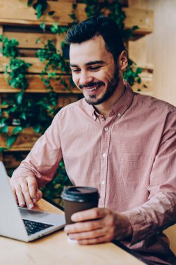 Kampüs coffet Kupası ile dinlenme dizüstü bilgisayar arkadaş genç öğrenci zevk sohbet gülümseyen, müreffeh erkek serbest meslek sahibi netbook yeni app indirme uzaktan çalışma ile memnun