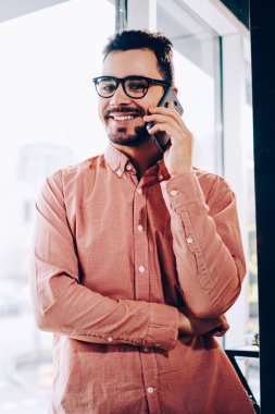 Cep pencere duran, Genç adam tarifeler telefon cep telefonu konuşma bir arkadaşım olması için memnun gülümseyerek telefonu konuşurken rahat kıyafet neşeli hipster adam portresi