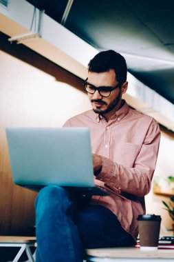 Genç erkek programlama verimli iş dizüstü bilgisayarlar ile işbirliği geliştiriciler iş birlikte, onun meslektaşım app işbirliği için ofiste oturan netbook üzerinde görünen adam gülümseyen BT