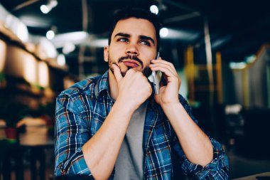 Düşünceli hippi adam, kafede arkadaşlarıyla telefonda konuşurken, cep telefonundan müşteri destek hattıyla bağlantı kurmayı bekleyen düşünceli bir genç adamla buluşmayı düşünüyor.