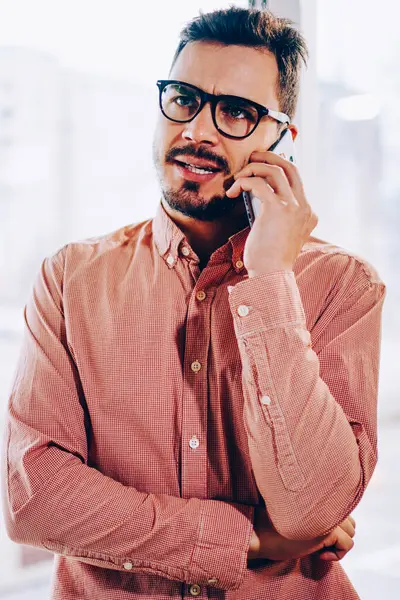 Erkek işadamı cep telefonu operatörüyle konuşurken hoşnutsuz bir yüz ifadesi takınıyor, genç hippi müşteri destek hattını beklemekten rahatsız oluyor, sorunu çözmek için çağrı yapıyor.