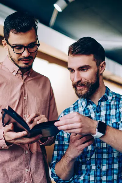 Bilgi için proje, olumlu hipster erkekler birlikte office coworking fikirler tartışırken Not defteri planından öğrenme hakkında konuşmayı okuma birbirleriyle konuşan genç erkek arkadaşları