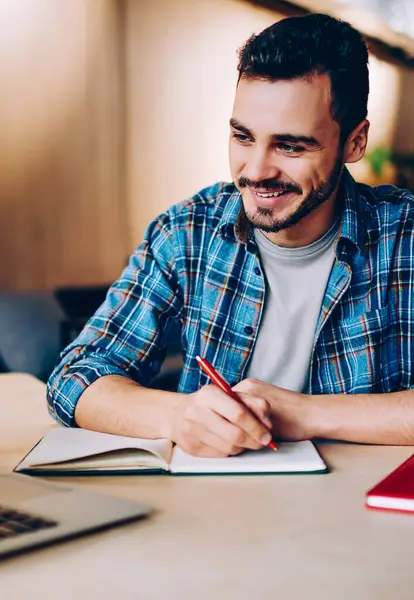 Dizüstü bilgisayarda dizayn etme ve bilgi toplama konusunda eğitim gören genç ve pozitif bir erkek öğrenci. Kafede internet üzerinden dil öğrenmeyi seven zeki hippi.