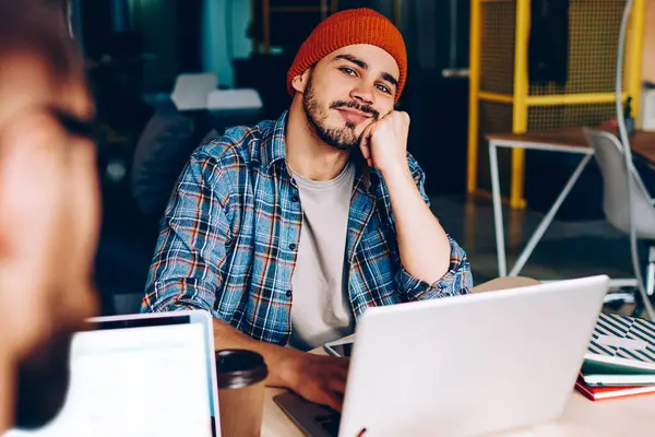 Üniversitede öğrenmek için dizüstü bilgisayarın başına oturmuş kameraya bakan düşünceli hippi adam. İş sırasında iş arkadaşlarıyla bir şeyler hayal eden bir erkeğin kırpılmış görüntüsü.