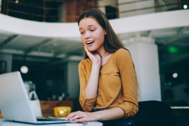 Şok olmuş kız öğrenci internetteki indirimlerle ilgili haberlerle e-posta aldı. Duygusal hippi kız üniversitede oturmuş dizüstü bilgisayarla inanılmaz videolar izliyor.