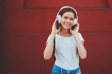 Gülümseyen kadın melodinin yarım boy portresi kulaklıkla yeni şarkı listesinden keyif alan neşeli kadın açık havada radyo yayını şarkıları dinleyen modern stereo ekipmanları boş zamanlarında kullanan kadın.