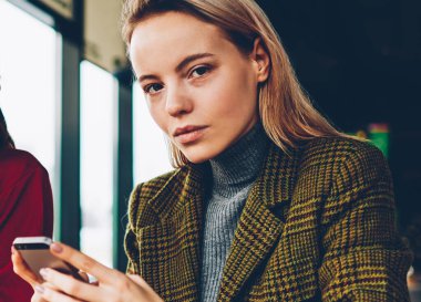 Yarım uzunluk portre iki başarılı tasarımcıların fikirler Smartphone cep telefonu ile arama ve kroki teamworking coworking içinde çizim yaparken kameraya bakıyor. Mobil ve olumlu öğrenci ile sarışın öğretmen