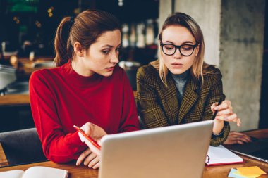 Ayrıntılar teamworking modern dizüstü bilgisayar, tartışırken iki profesyonel grafik tasarımcıları. Yetenekli öğrenciler Webinar online yolu ile 4 g netbook üzerinde izlerken internet ve fikirler işbirliği sırasında analiz