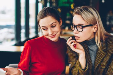 İki şüpheci yetenekli öğrenciler dizüstü bilgisayarda internet sitesinde tasarım tutorial online izlerken bilgi analiz ve tartışmak için kablosuz 4 g bağlı oturma alanı coworking internet