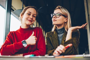 İşaret gibi gösteren ve kamera rüya gibi sarışın arkadaş Üniversitesi'nde masada oturan planları hakkında gözlük düşüncesinde ise gülüp başparmak ile mutlu esmer öğrenci portresi yarım uzunluk