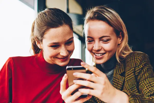 Canlı izlerken olumlu kız öğrenci blog Smartphone cep telefonu ile akışında bağlı 4 g internet kafede sınava hazırlık sırasında. Mutlu genç kadın telefonu sosyal ağlar komik yorum okuma