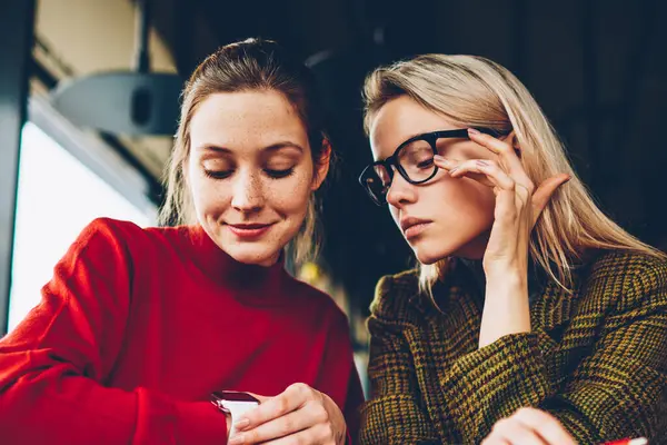 Eğitim zaman alan coworking içinde düzenlemek için düşünceli öğrenciler modern smartwatch göstermek vasıl arıyorum. Hippi kız kafe iç dostu toplantı sırasında kol saati kontrol