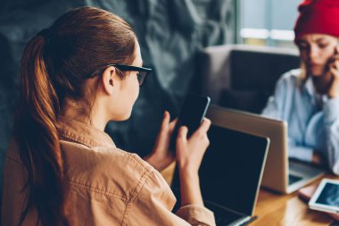 Seçici odak üstünde esmer hipster blogger üzerinden 4 g smartphone uygulama yükleme Internet serbest coworking ile birlikte arkadaş hangi hücresel üzerinde konuşmak içinde bilgisayar üzerinde çalışırken