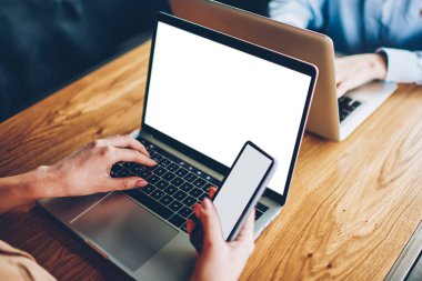 Kırpılmış görüntü öğrencinin eller klavye modern dizüstü bilgisayar aygıtının sahte mesafe iş sırasında bilgi arama alanı ile yazarak. Bluetooth ile modern netbook smartphone üzerinden medya paylaşımı