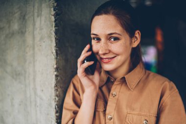 İstek-e doğru Smartphone cep telefonu ile arkadaş süre kamera gülümseyen pozitif genç kadın yarım uzunluk portre. Telefonda konuşmayı şirin neşeli öğrenci. Cep üzerinde konuşmak mutlu hippi kız