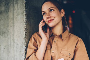 Smartphone üzerinde arama ve işleç ile konuşmak için telefon hattında bekliyor elinde ders kitabı ile şirin hippi kız. Boş zamanlarında üzerinde modern hücresel iletişim oldukça olumlu genç kadın