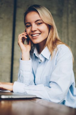 Başarılı kadın çevirmen kafe iç oturan boş zaman zaman içinde smartphone dostu mobil konuşma yaparken kameraya gülümseyen portresi. Pozitif hippi kız cep üzerinde arama