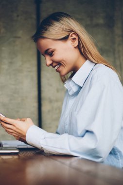 Mutlu hipster smartphone aygıt takipçileri ile blogger online sohbet yan görünümü bağlı 4 g ağlarda mesajlaşma space.positive öğrenci coworking içinde modern netbook oturan internet