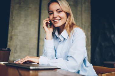 Başarılı kadın çevirmen kafe iç oturan boş zaman zaman içinde smartphone dostu mobil konuşma yaparken kameraya gülümseyen portresi. Pozitif hippi kız cep üzerinde arama
