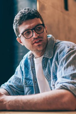 Gözlüklü, beyaz tenli, sosyal ağlardaki profili güncellemek için vaktini harcayan yakışıklı, düşünceli, modern teknolojiyi takipçilerle mesajlaşmak için kullanan biri.